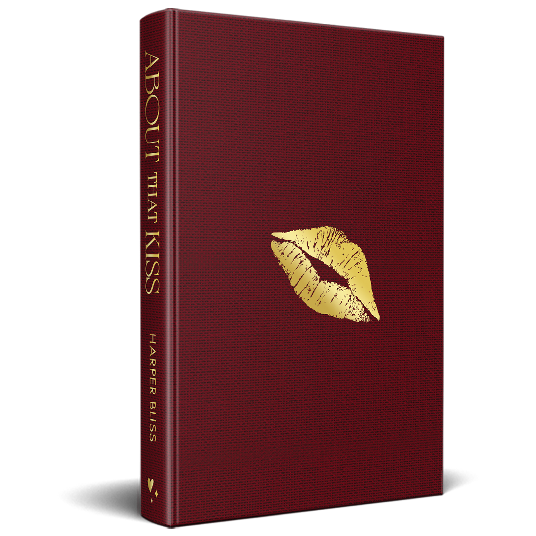 Mockup of the “About That Kiss” special edition hardcover in deep red cloth with gold foil lips on the front and the title on the spine.
