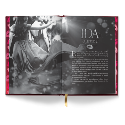 Open-book interior mockup for “About That Kiss” showing a black-and-white chapter header spread titled “IDA, Chapter 2” with a photo-style image of two women in dresses.